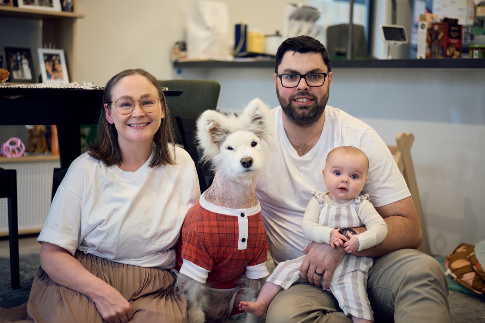 Family reading a picture book together with the baby on the couch