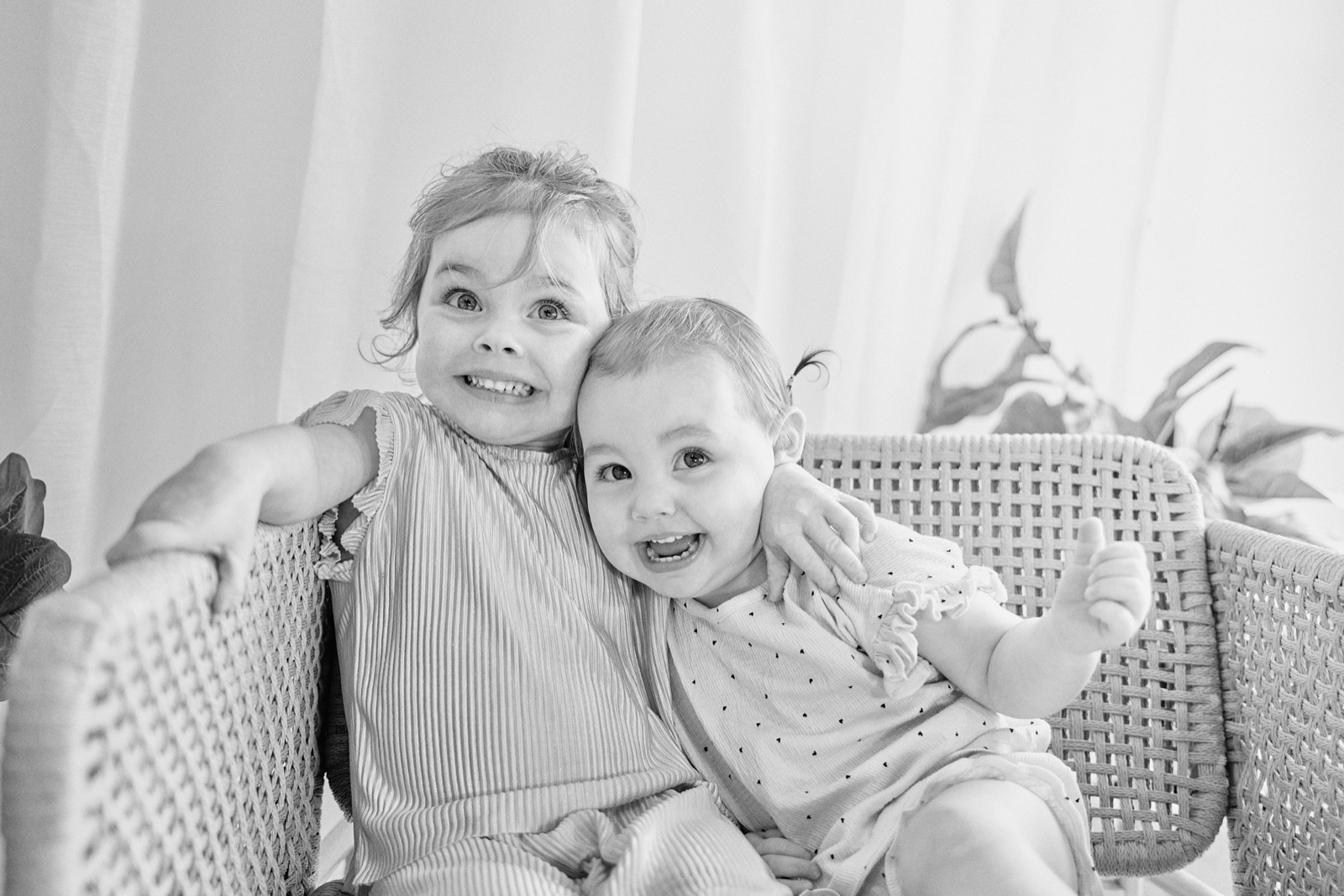 Mum on the bed with her two young daughters in soft natural light