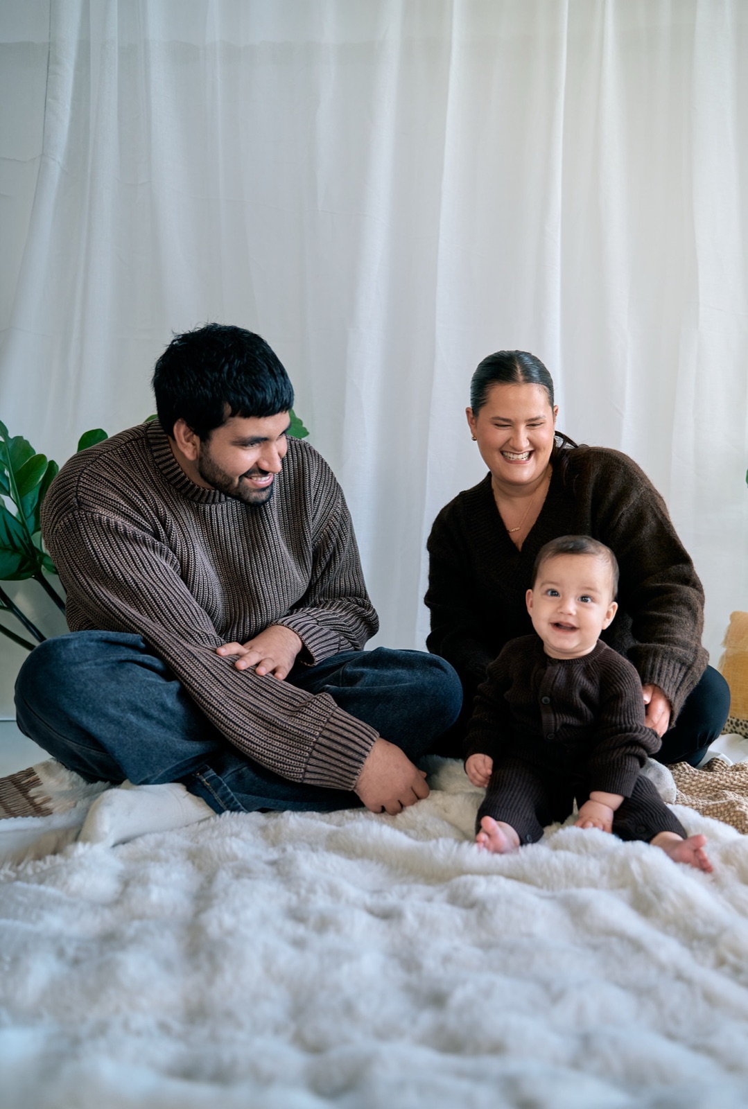 Parents and their two kids piled together on the bed