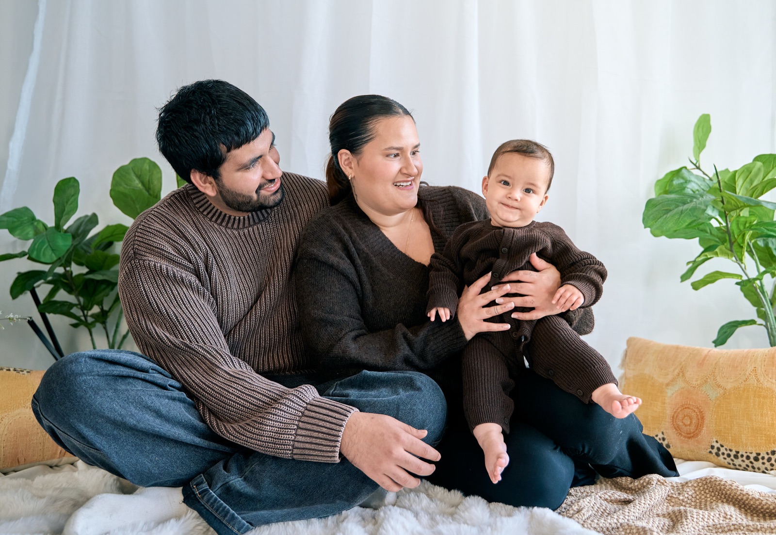 Family of four together on the couch, relaxed at-home portrait