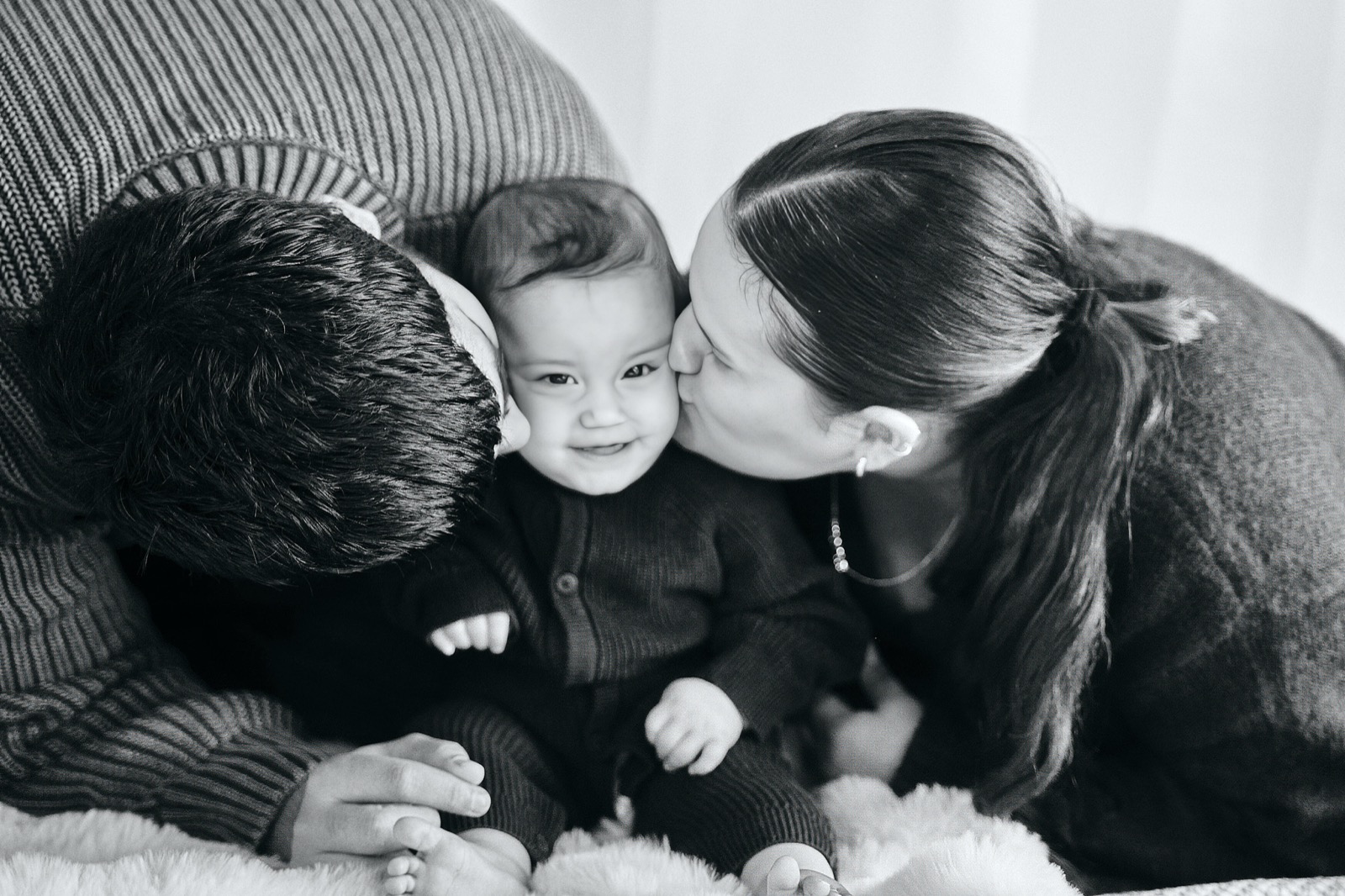 Black and white family huddle with arms wrapped around each other