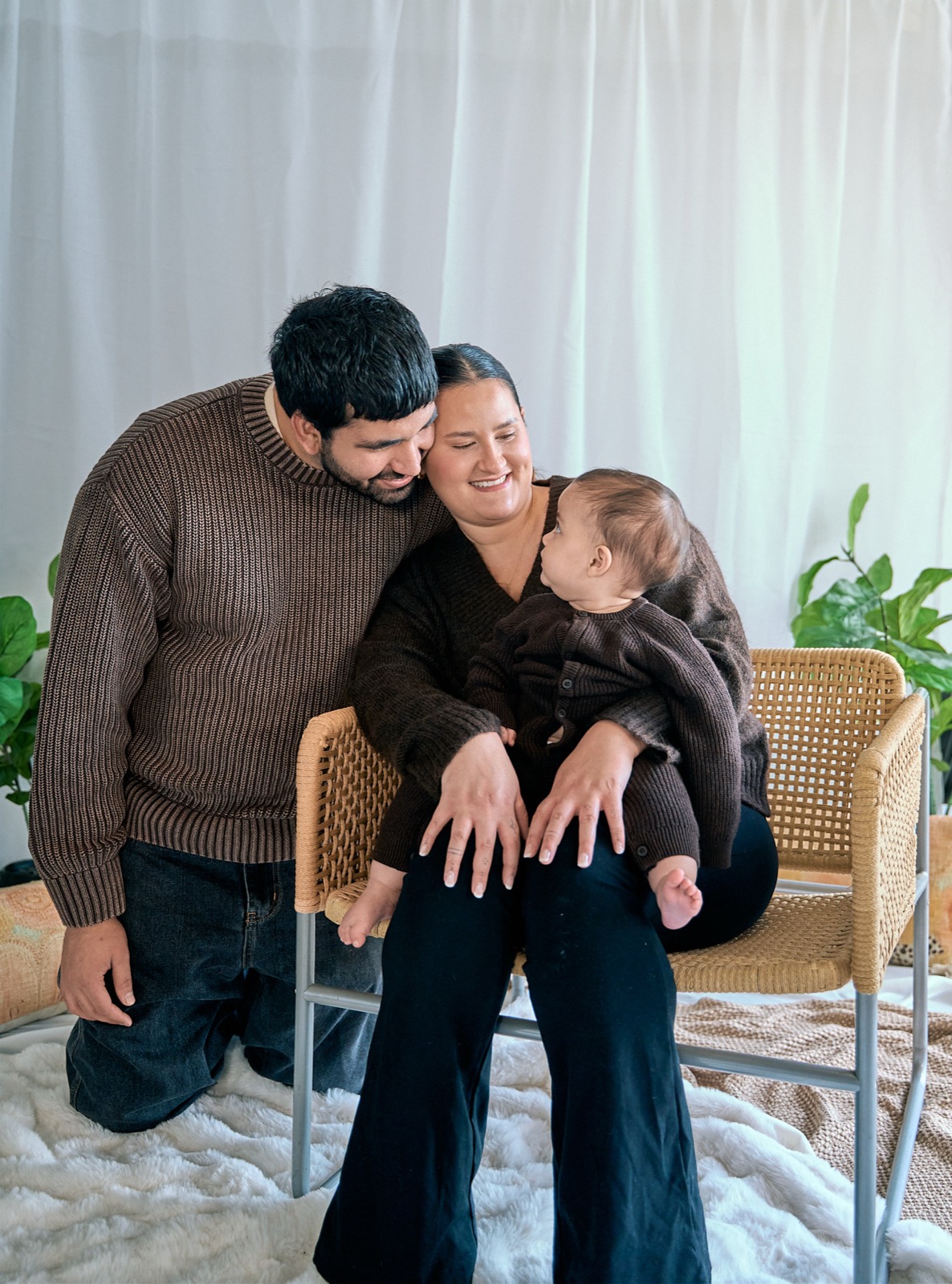 Parents kissing with their toddler snuggled between them