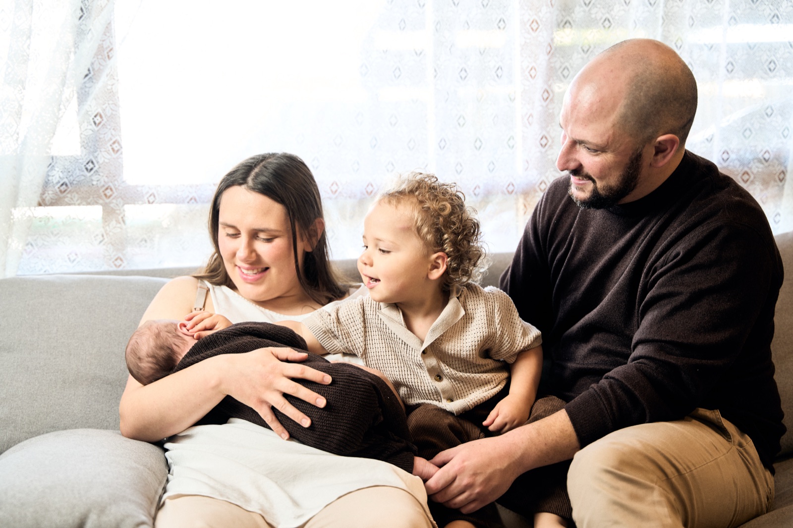 Dad on the couch with his toddler and newborn, in-home family photography Frankston
