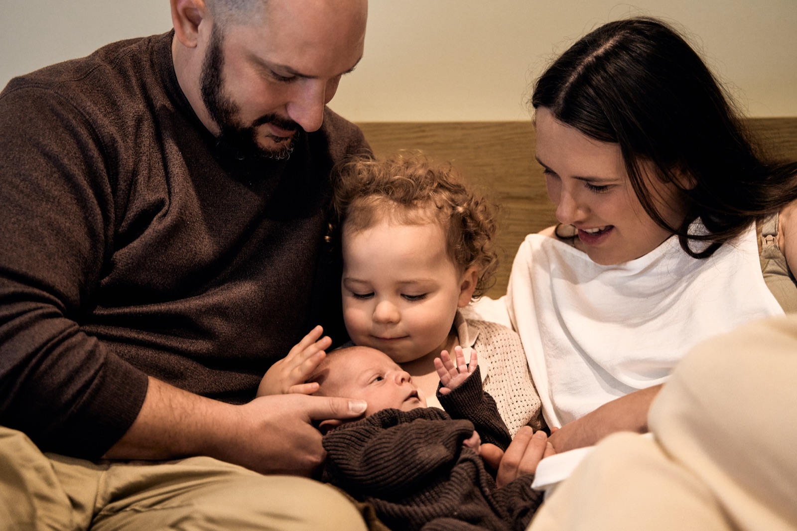 Mum with her toddler and new baby on the couch, relaxed in-home family session
