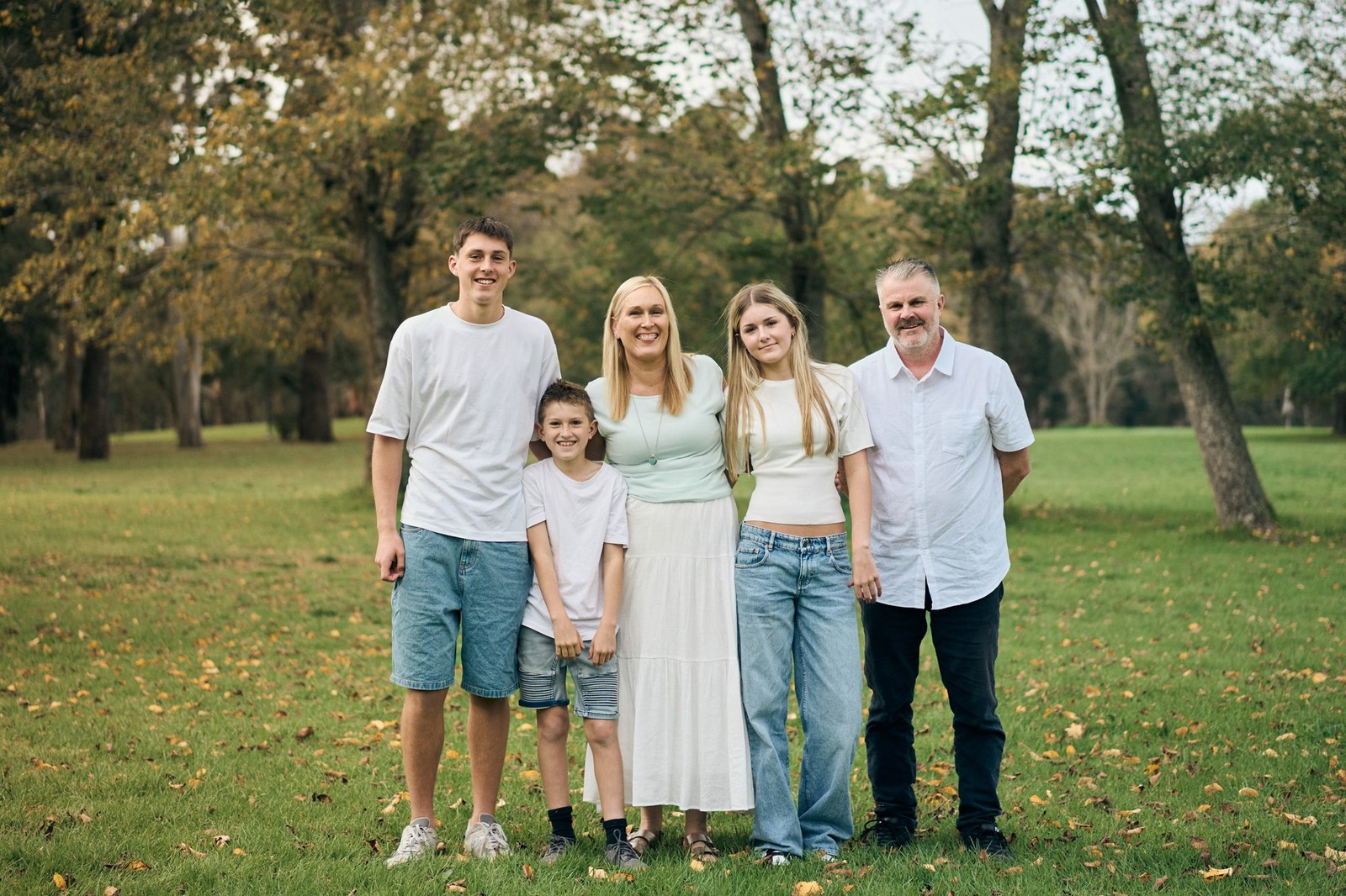 Parents and their three older children on the grass during an autumn family session