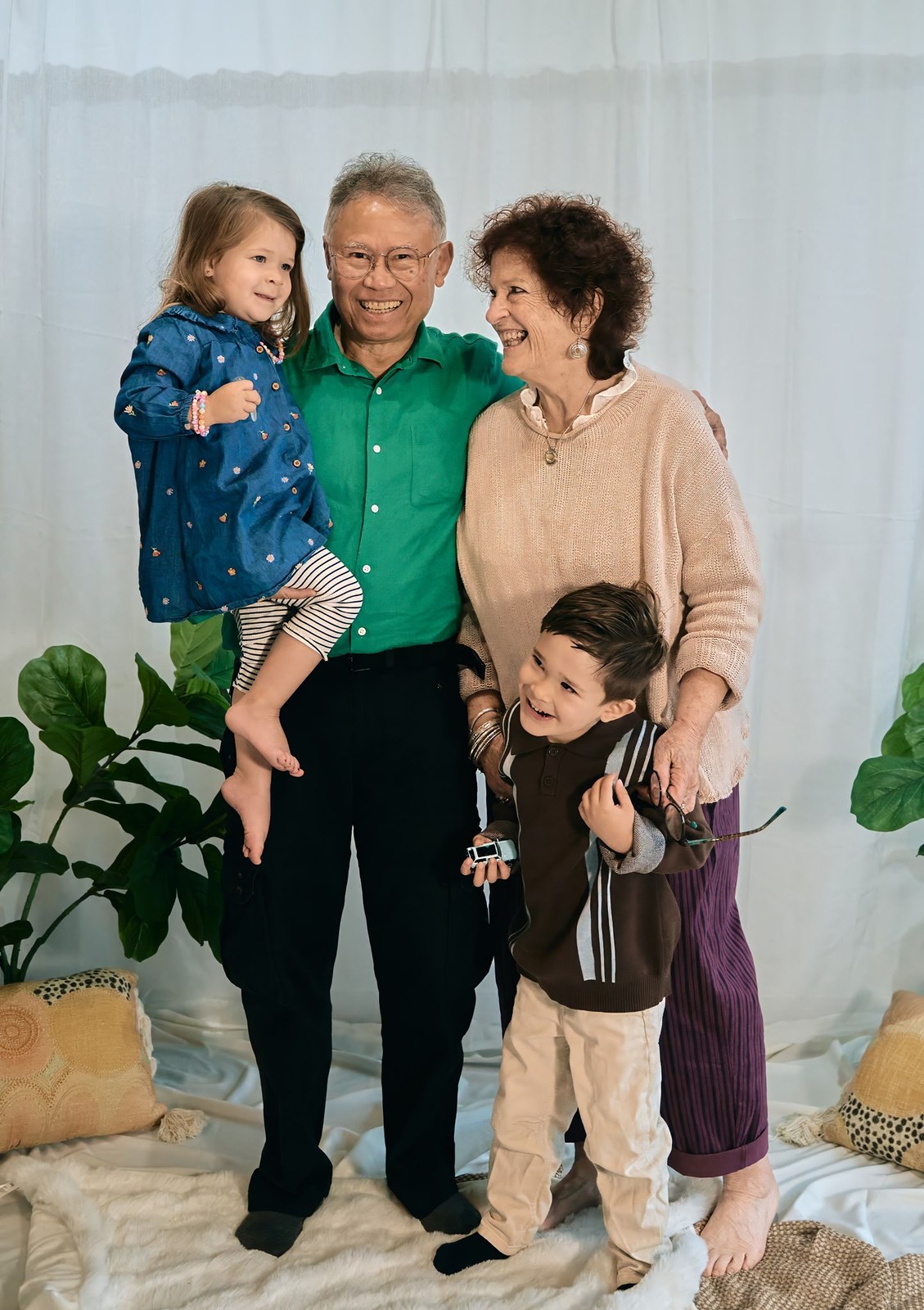 Grandparents with their two grandchildren against a soft studio backdrop