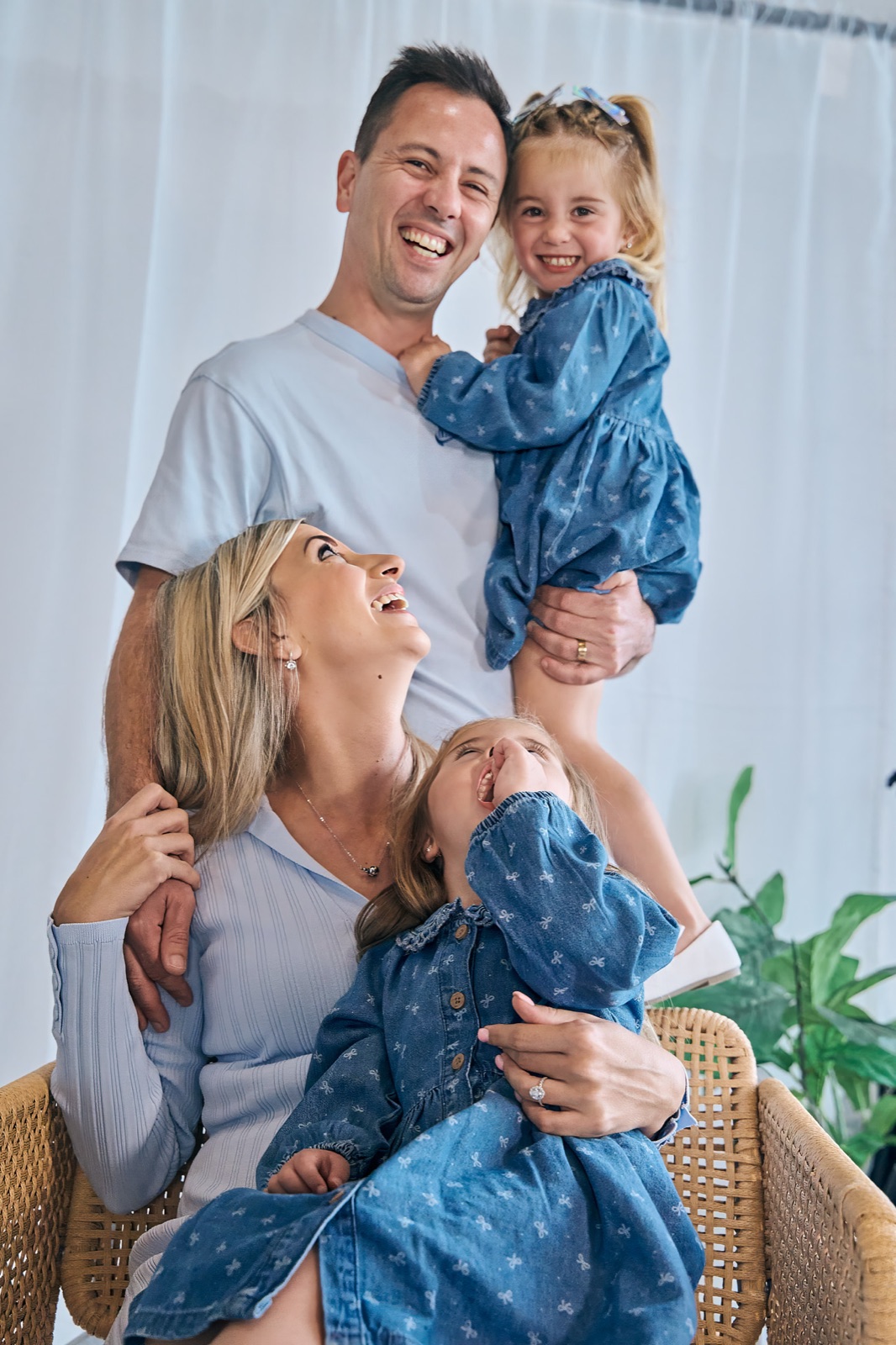 Young family cuddled up together during an at-home session