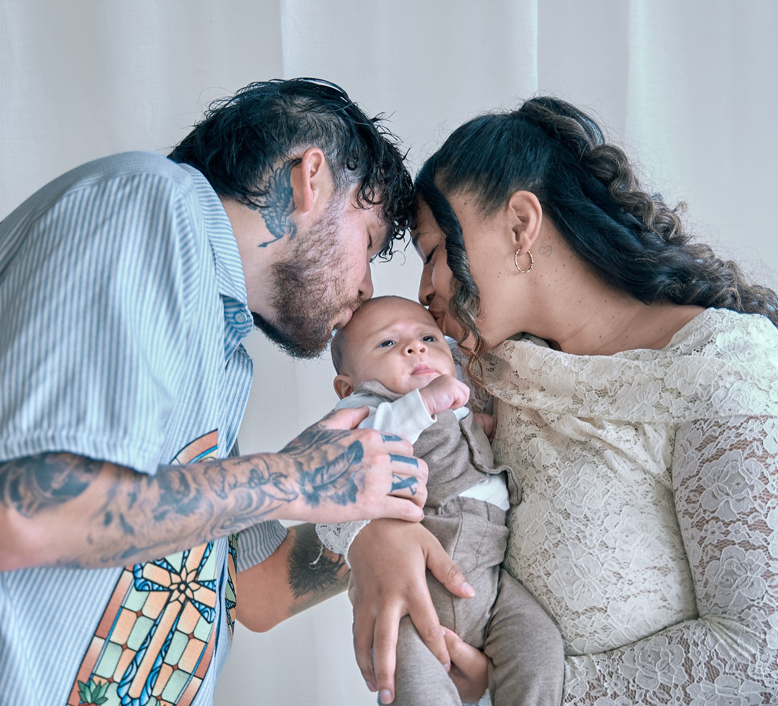 Parents nose to nose with their baby between them