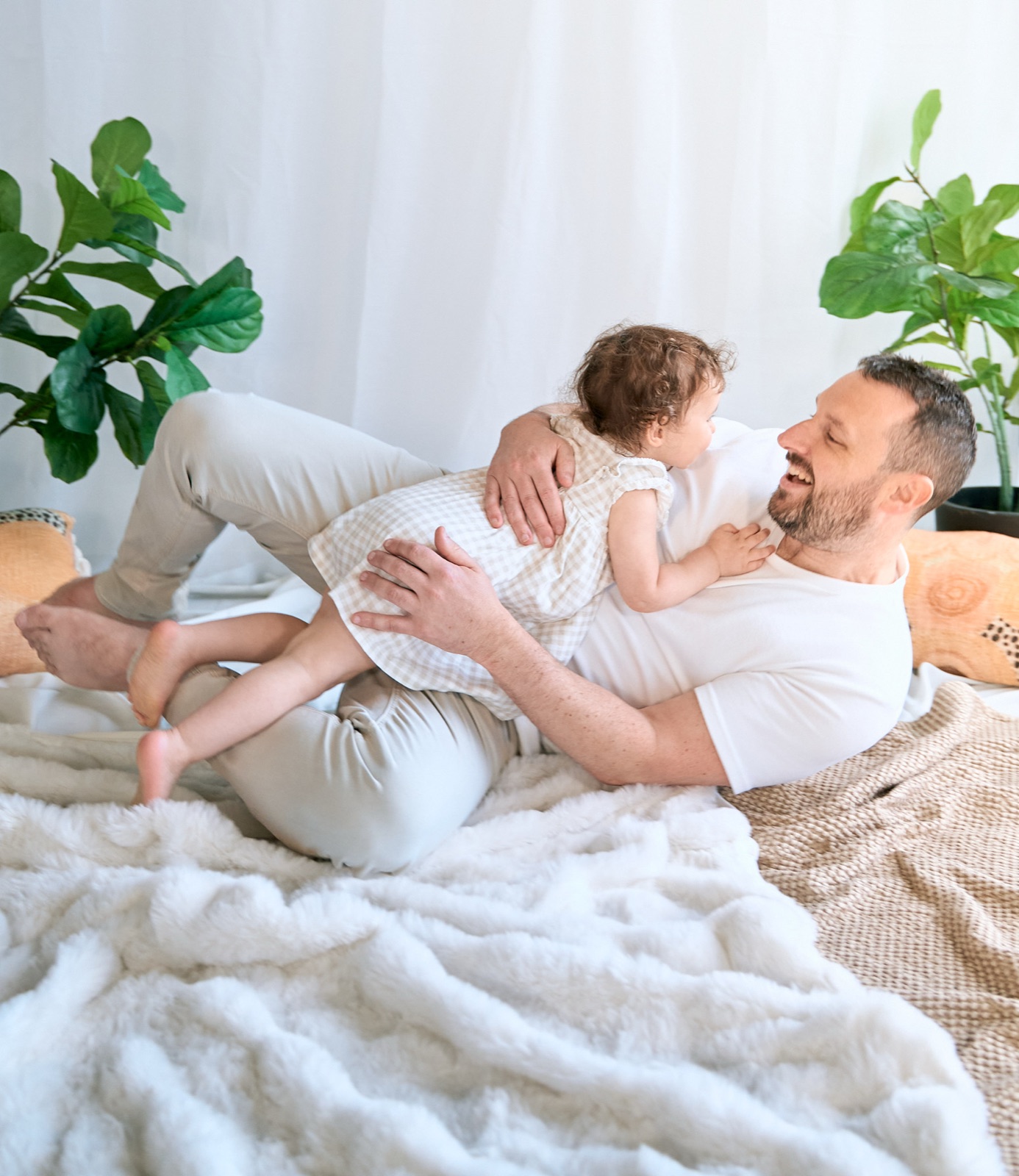 Dad lying on the bed with his newborn resting on his chest