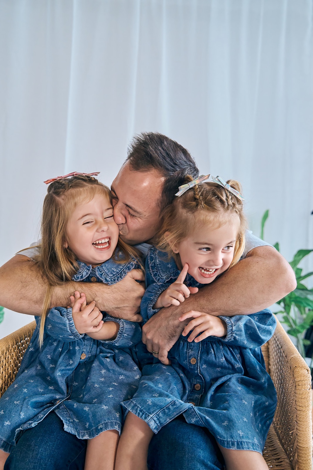 Dad laughing with his two girls, candid fatherhood portrait