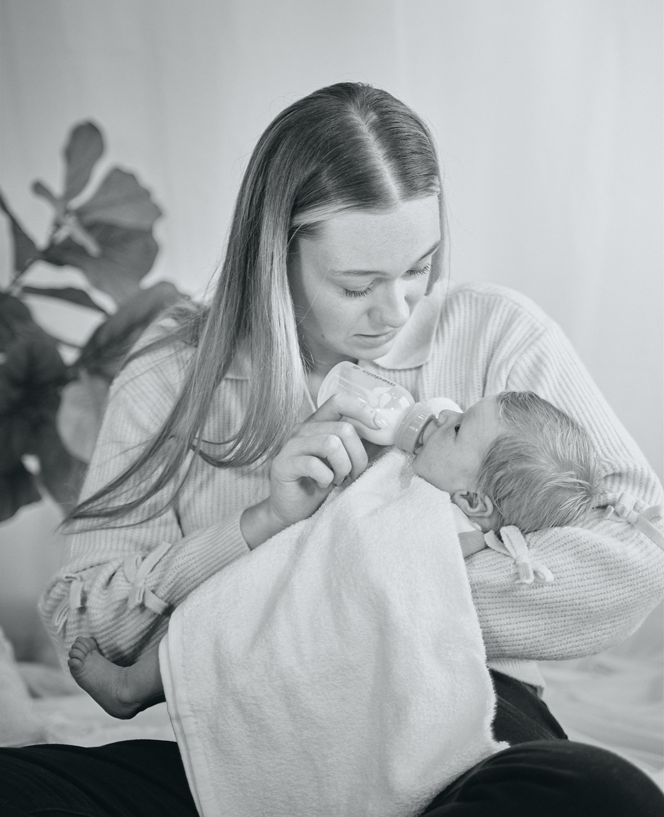 Mum smiling down at the newborn wrapped in her arms
