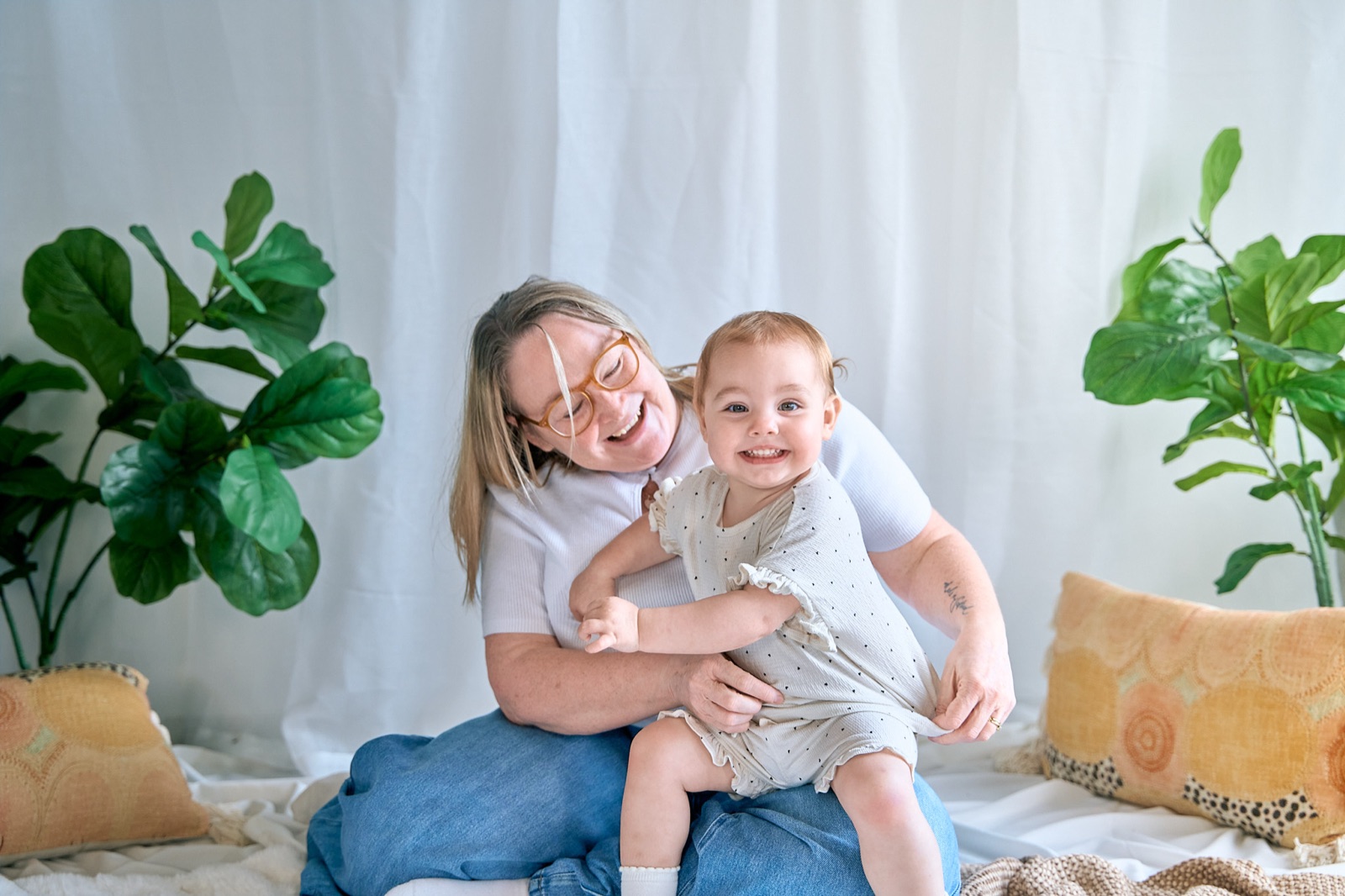 Mum and her baby playing on the bed, bright and airy in-home session