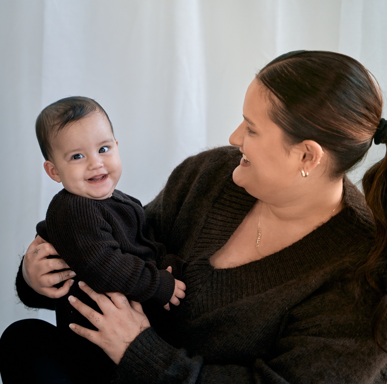 Mum laughing with her baby in her arms