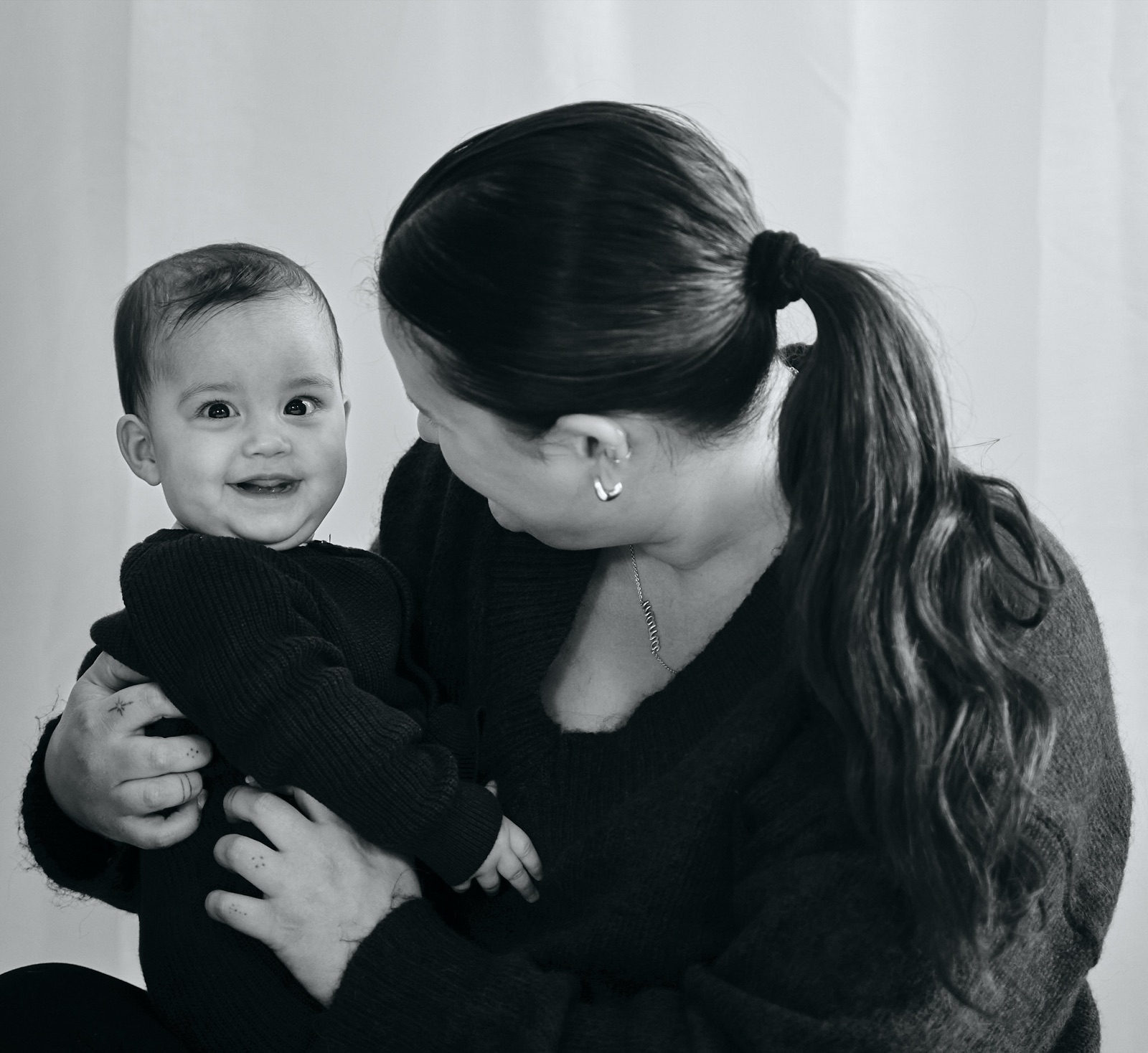 Black and white portrait of mum holding her little one close
