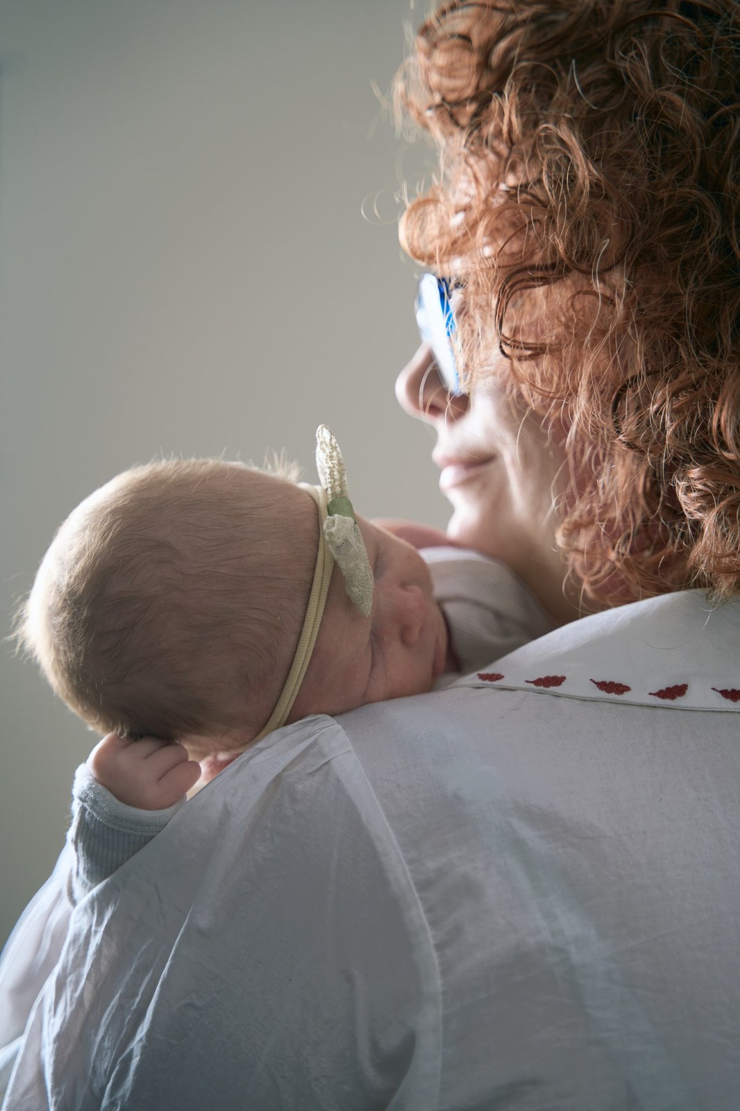 Mum holding her newborn daughter up against her shoulder