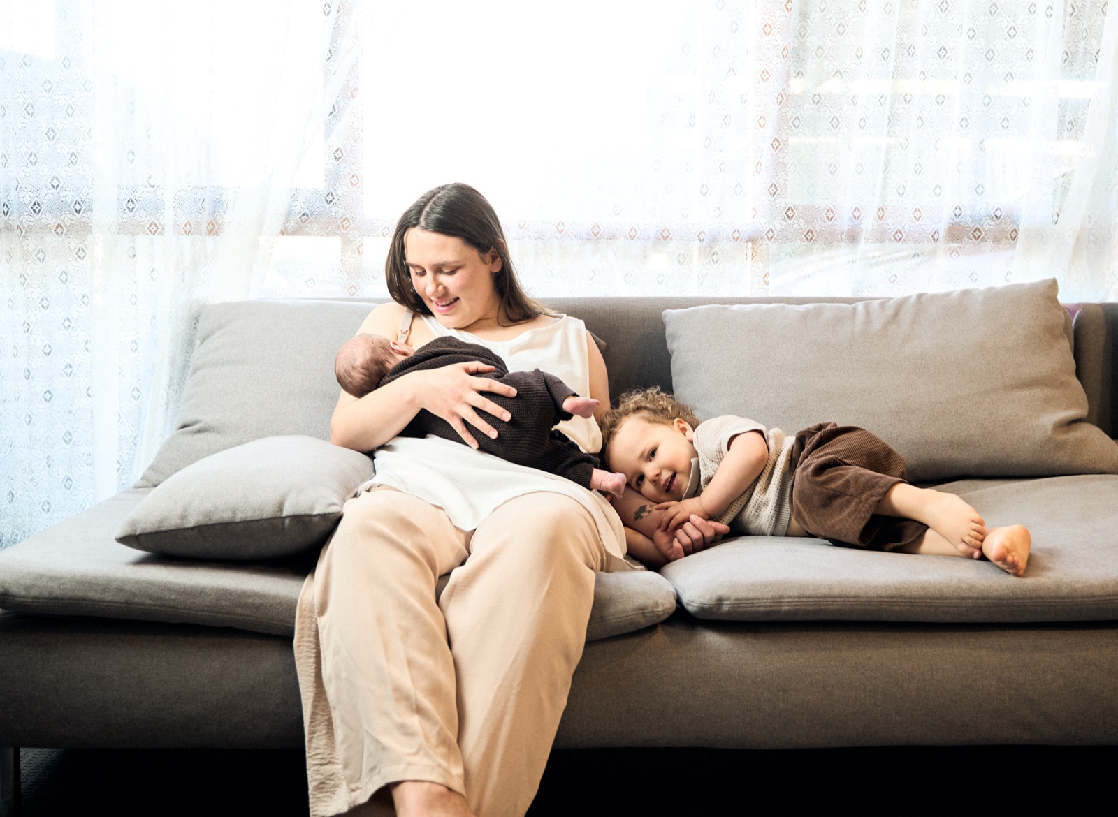 Mum nursing her baby on the couch, quiet everyday moment