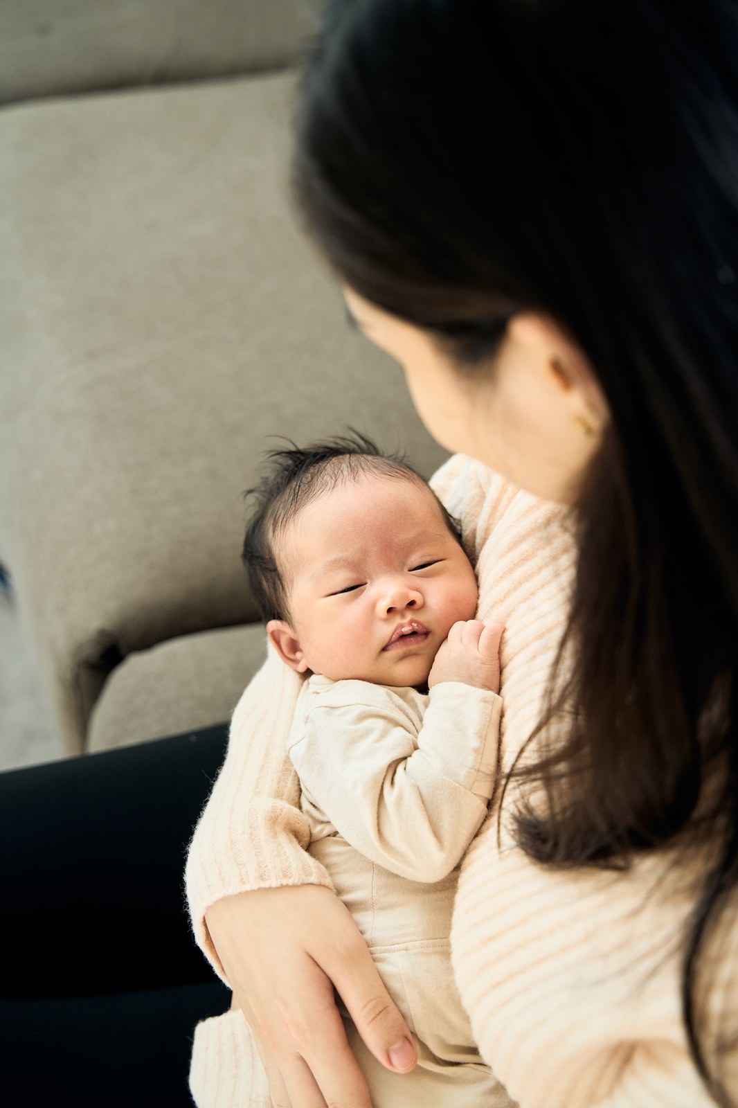 Mum holding her newborn upright against her chest