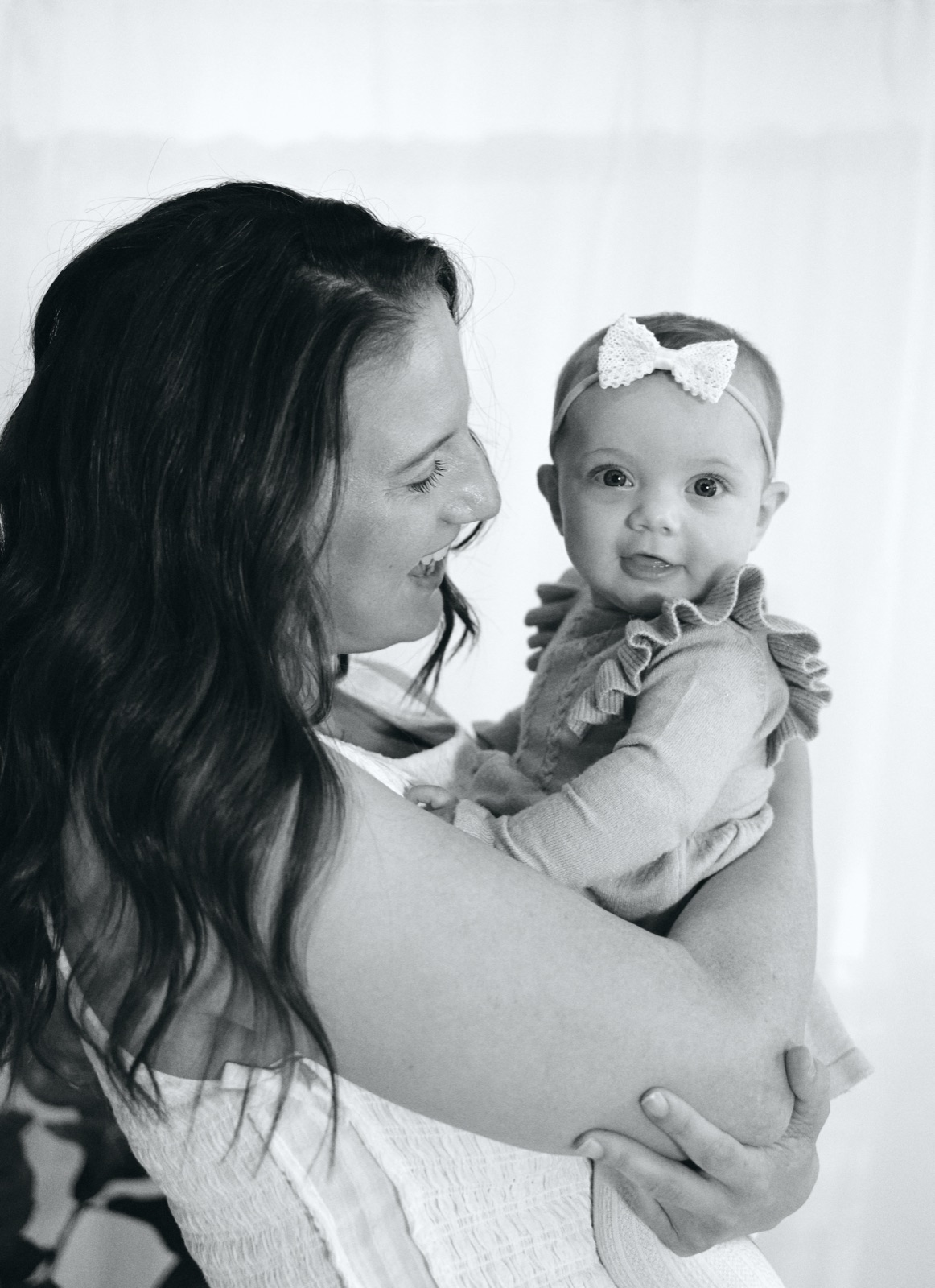 Mum holding her baby girl cheek to cheek