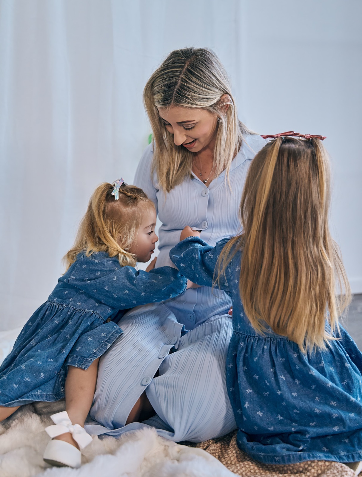 Mum with her two daughters in matching blue dresses