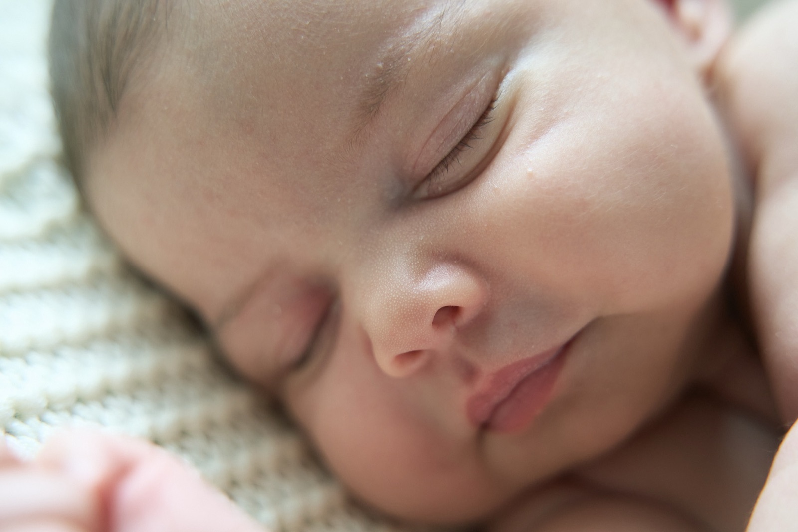 Newborn asleep in soft golden light, close-up