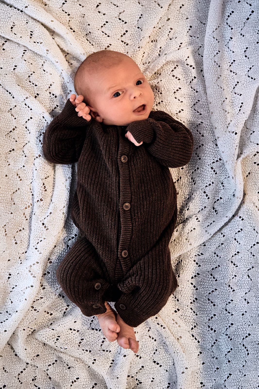 Newborn lying on a blanket, awake and alert