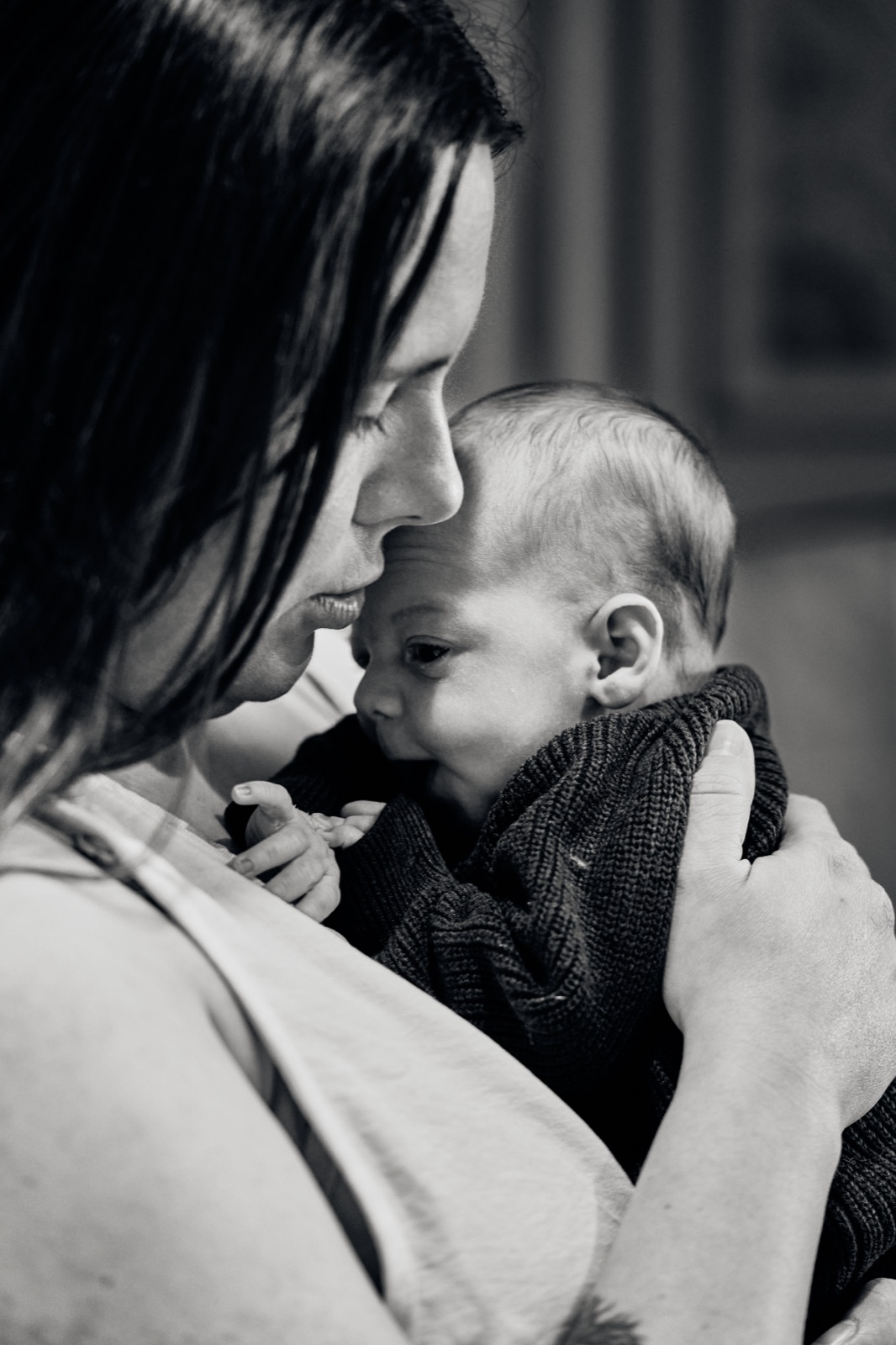 Mum breathing in her newborn, black and white close-up