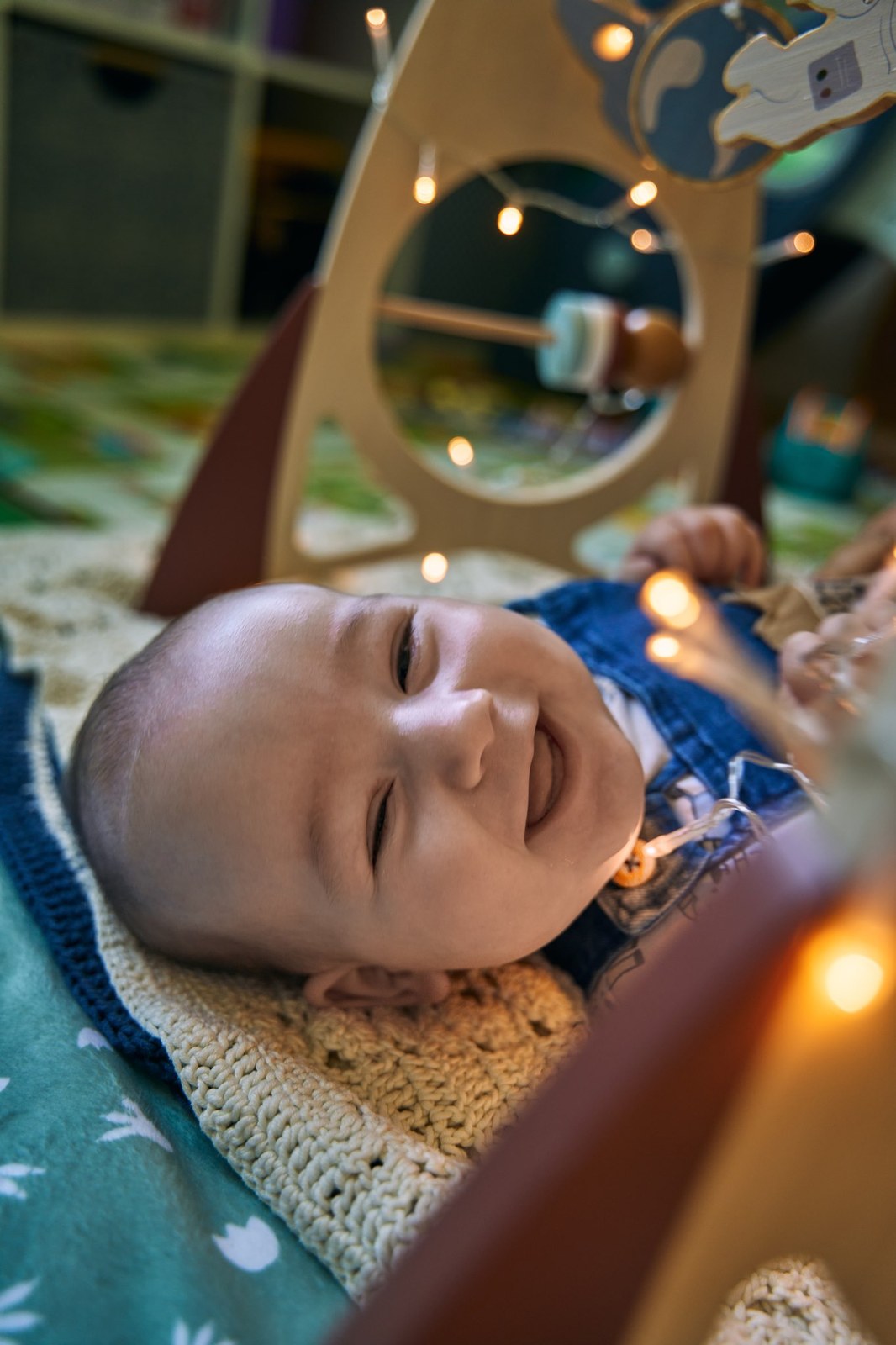 Baby laughing under the play gym in the front room