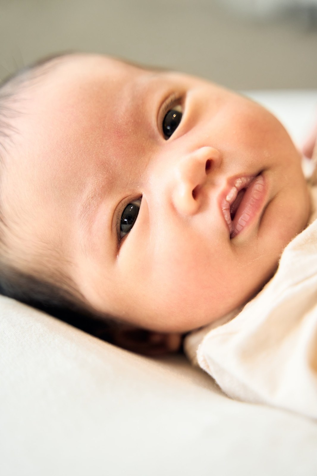 Newborn awake and alert, looking up from the blanket