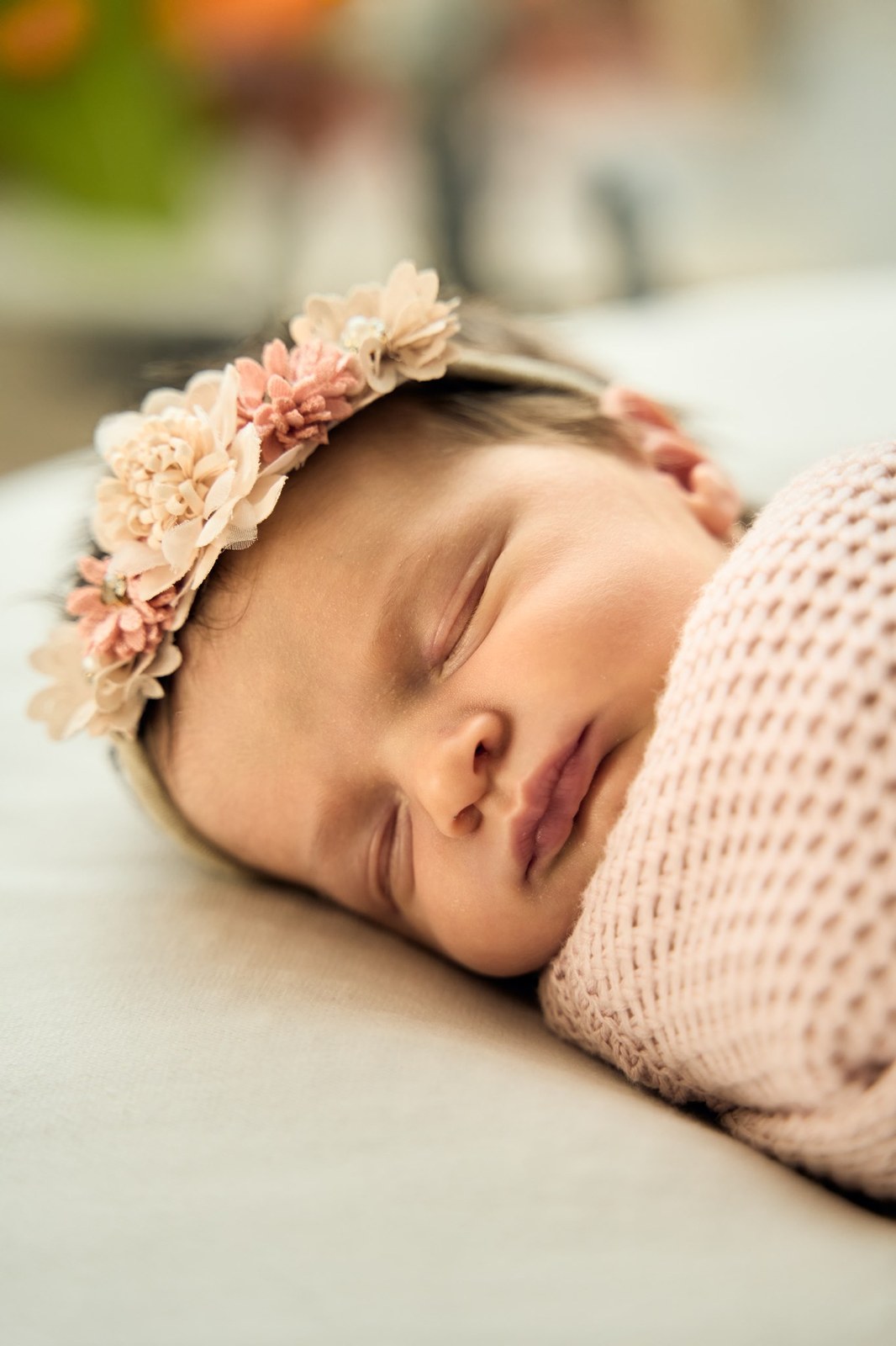 Sleeping newborn in a soft floral crown, close up