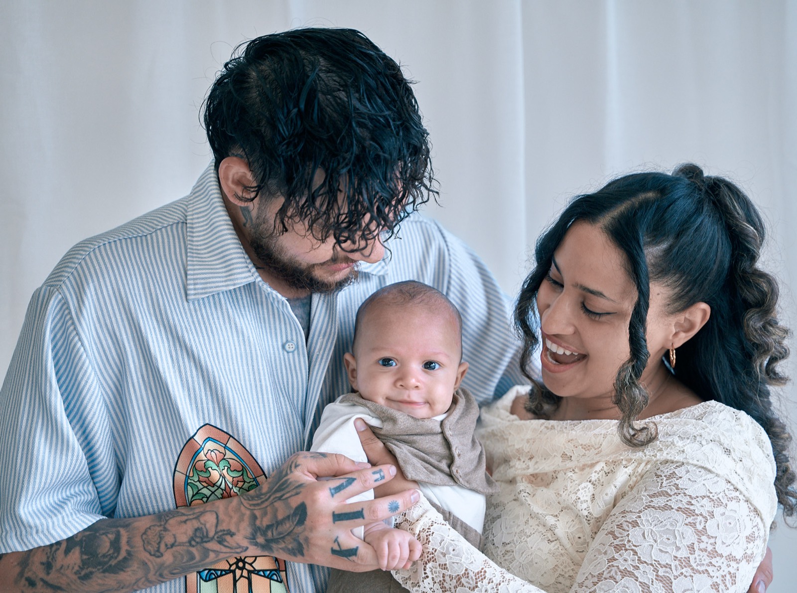 Mum and dad smiling over their newborn, bright in-home session