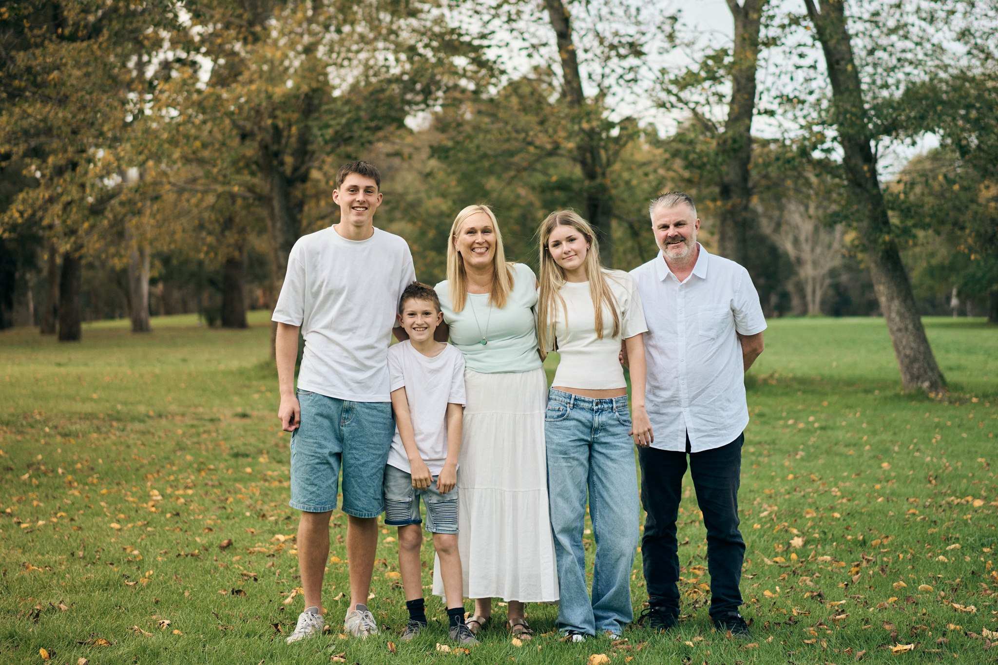 A family of five standing together in a park in autumn, outdoor family session South-East Melbourne